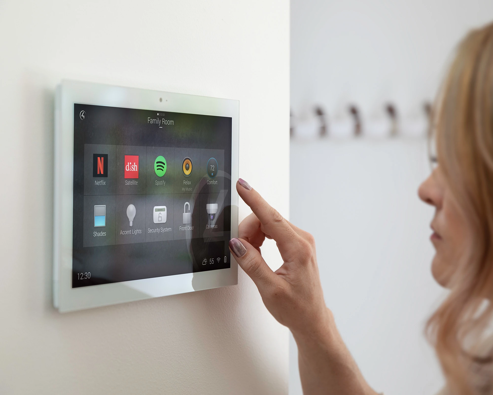 Woman interacting with Control4 smart home OS 3 on in-wall touch screen